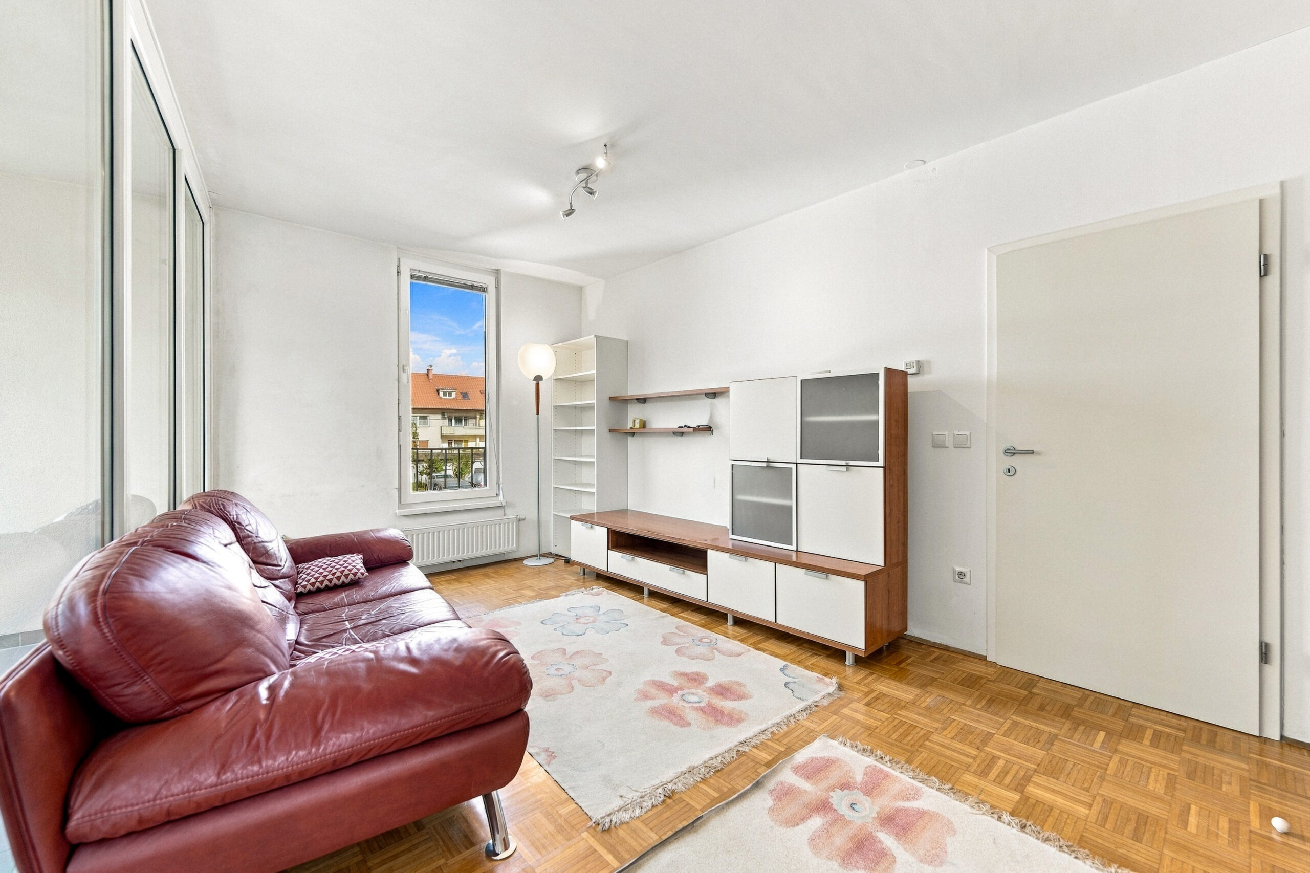 Living room with red leather sofa and shelving unit