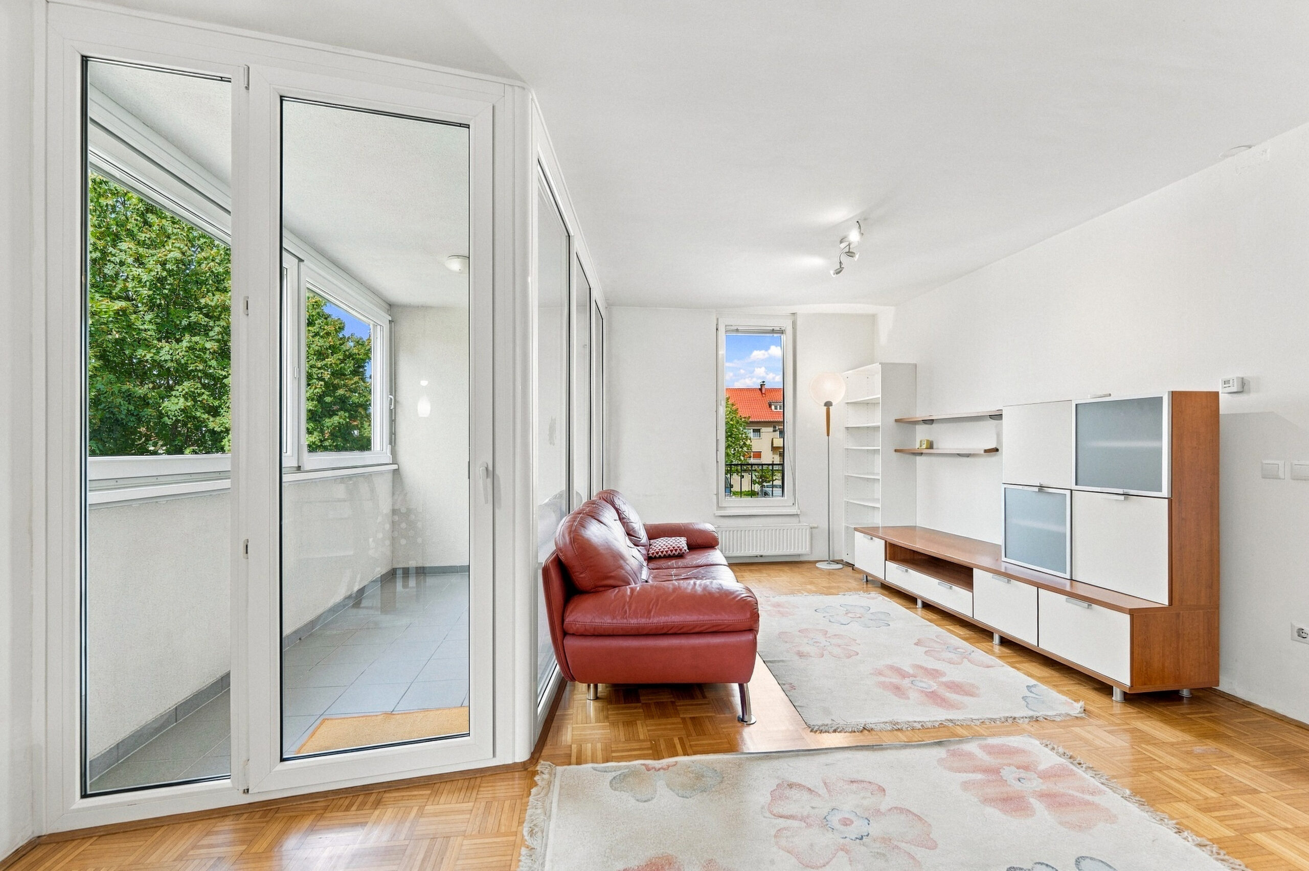Living room with balcony access and red sofa